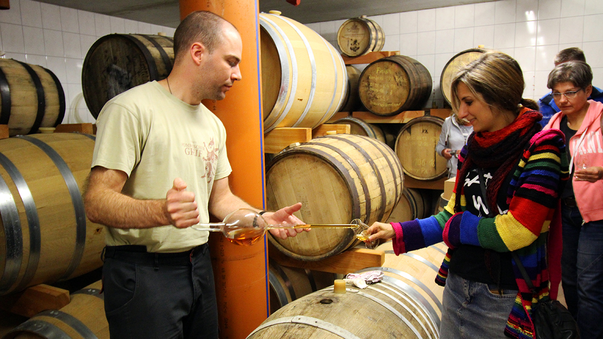 Der Brennmeister bei der Verkostung in der Hofbrennerei füllt gerade Whisky aus einem Madeira-Fass in ein Nosing-Glas eines Gastes
